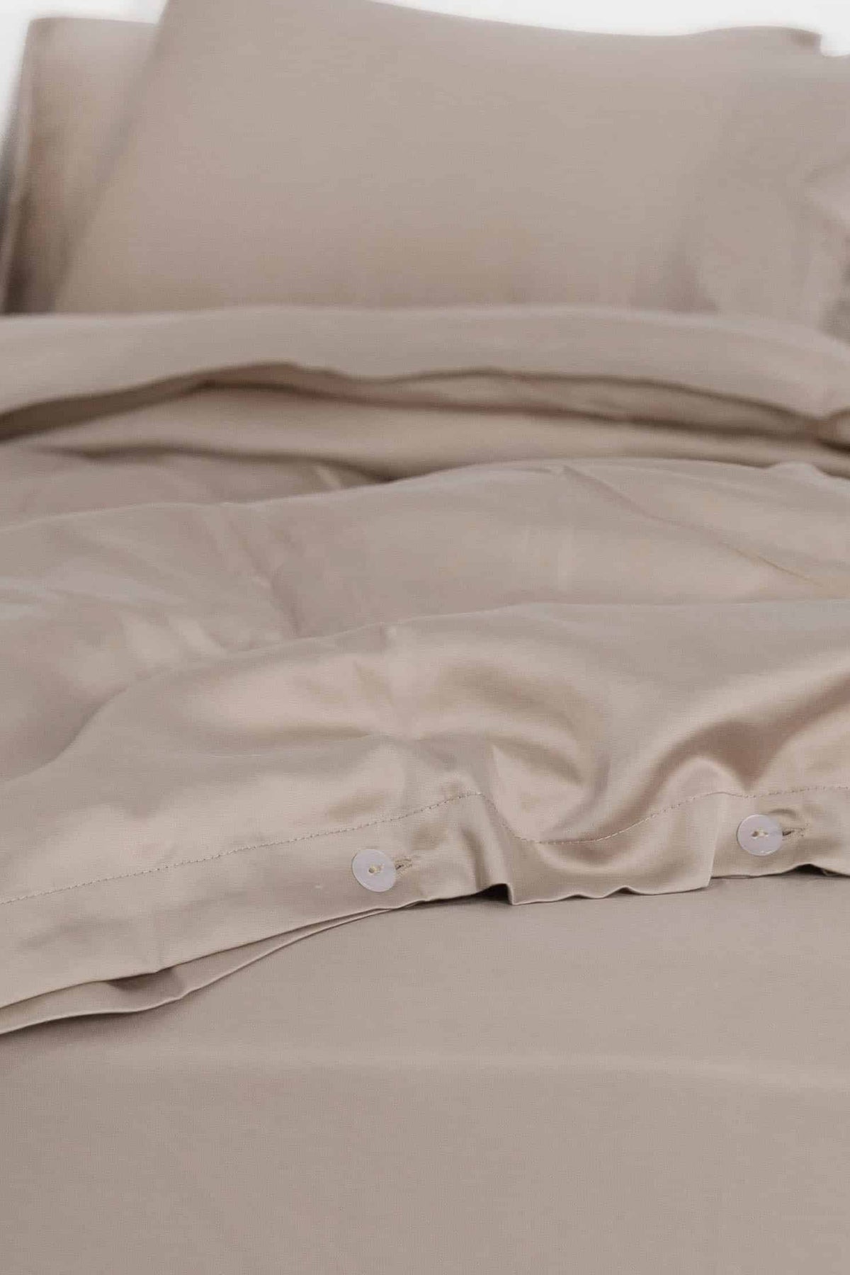 Rose dust bedding set with pillows on a white background