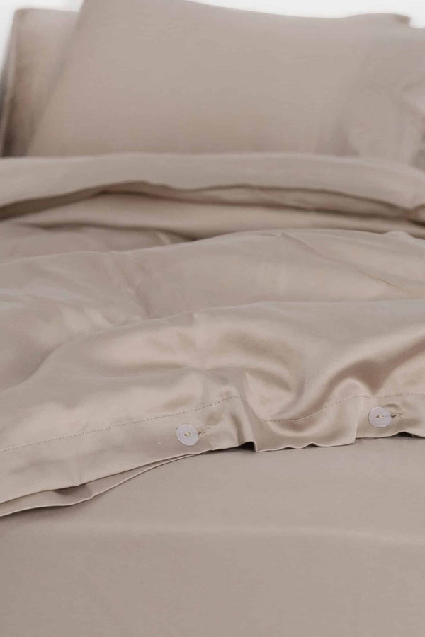 Rose dust bedding set with pillows on a white background